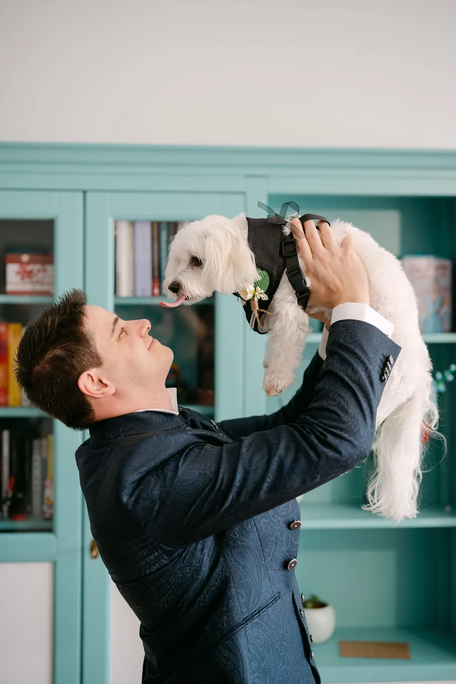 Groom holding his dog dressed for the wedding