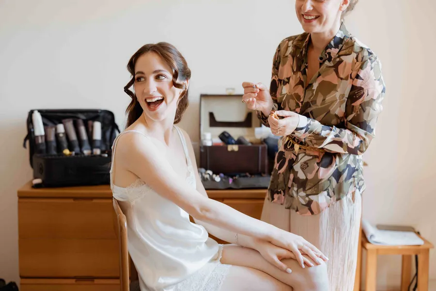 Bride laughing while getting ready on wedding morning