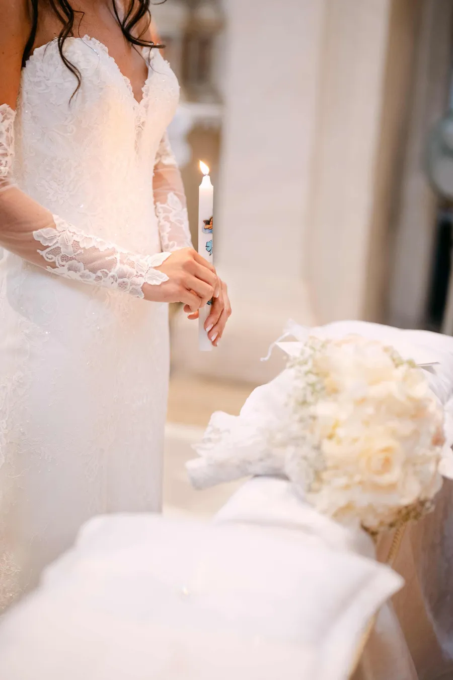 Bride holding ceremony candle with bouquet